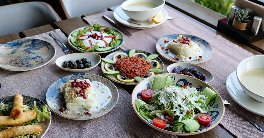 A table set with various meditarrenean dishes including salads, soups, and desserts.